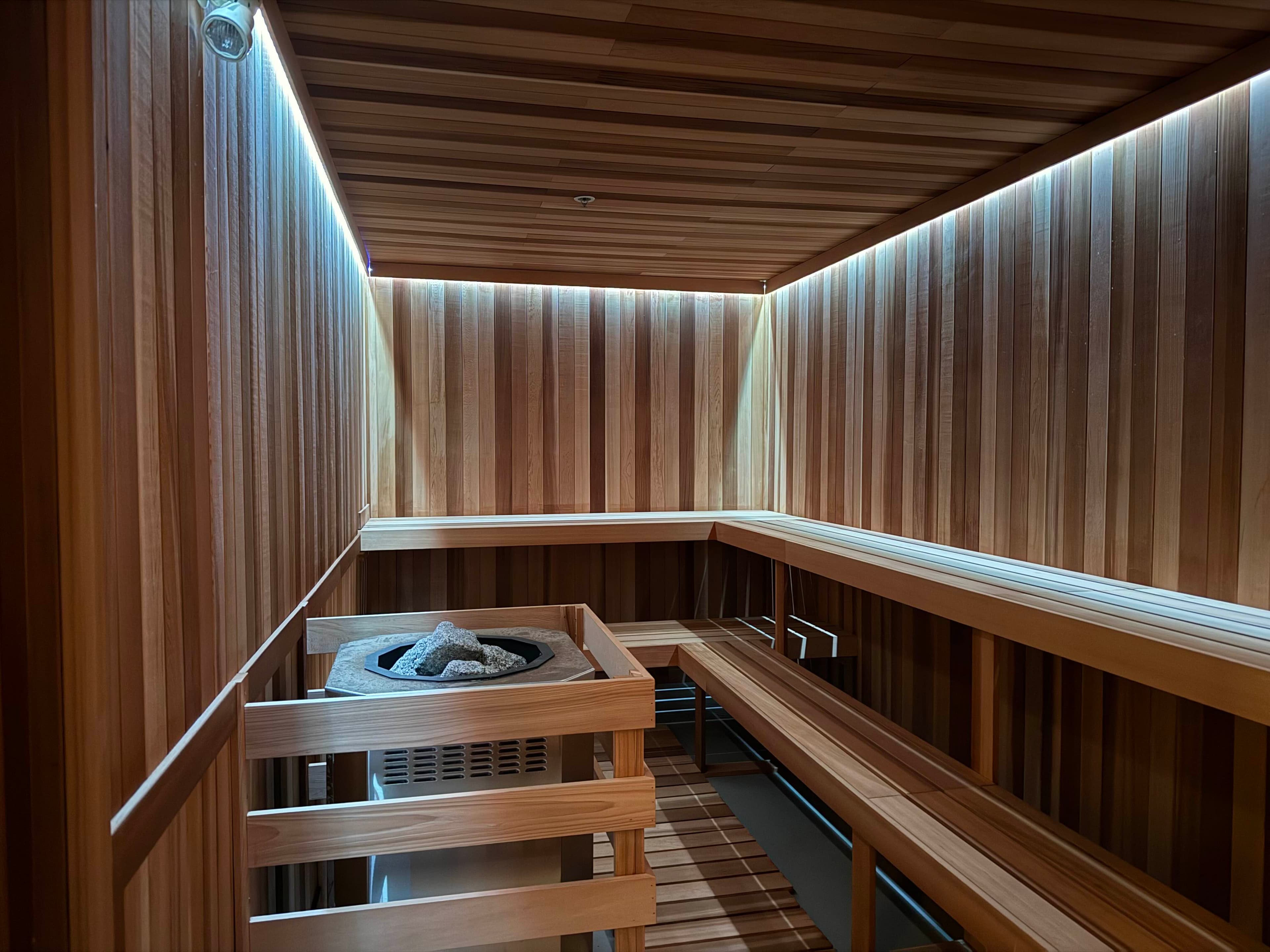 Reviva Lounge cedar sauna interior with stone heater and ambient lighting